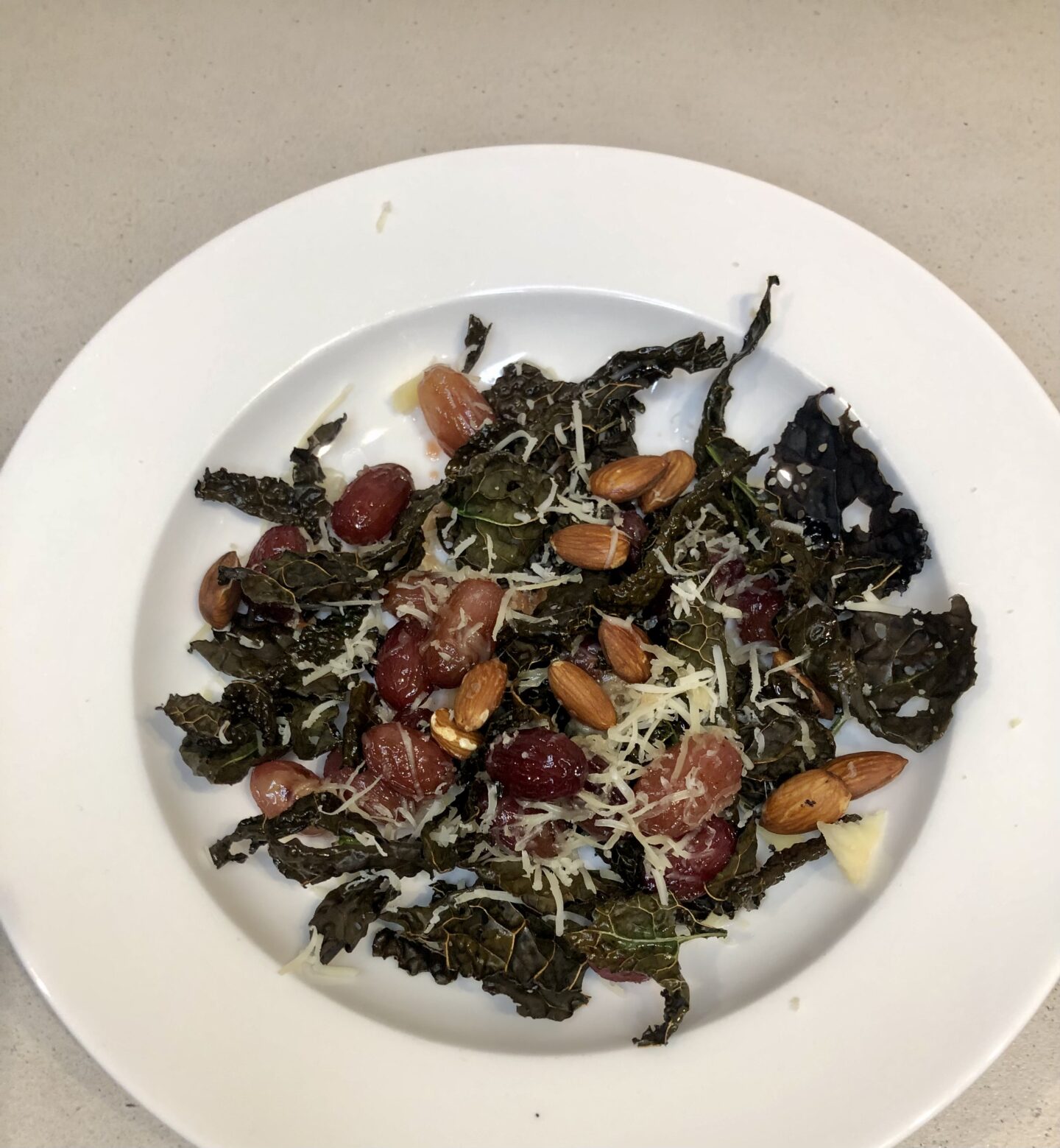 Warm autumn salad with kale, almonds, roasted grapes, and cheese